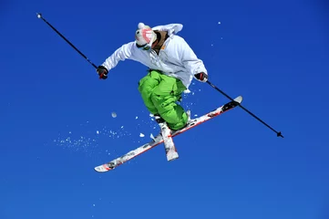 Poster skier in green and white performing a jump © camerawithlegs