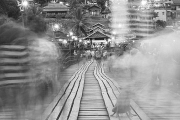 Black and white blur image of Traveler crossing bamboo bridge or Mon Bridge in Sangklaburi. Kanchanaburi, Thailand