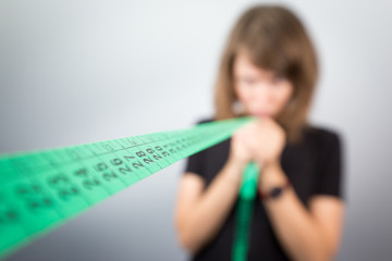 Woman holding pulling measuring meter tape, diet model studio.