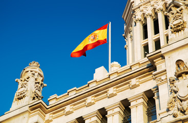 The flag of Spain fluttering on the Cybele Palace, Madrid