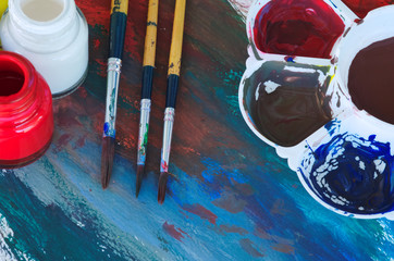 brushes and color palette with paint, close up
