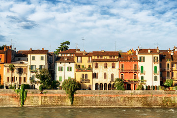 Fototapeta na wymiar Old houses on waterfront of the Adige River. Verona, Italy