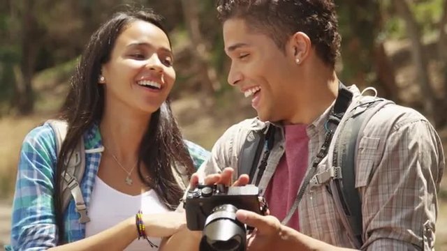 Young Mexican couple looking at pictures on camera