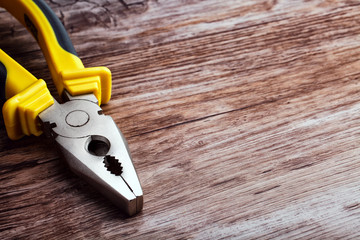 multitool pliers on wooden background