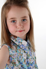 the charming cheerful little girl in a bright shirt poses in the camera
