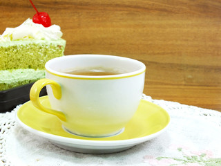 sweet cake with cup of tea on wooden table