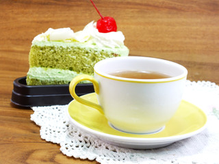 sweet cake with cup of tea on wooden table