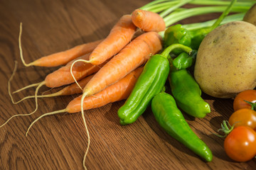Carrot and green chili pepper on wood background