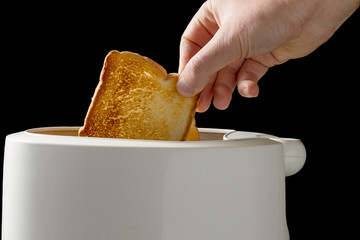 Hands of a man taking fresh toast out of a toaster isolated on black background with clipping path.