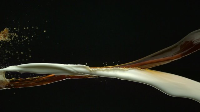 Pouring coffee & milk and making splashes on black background shooting with high speed camera, phantom flex.