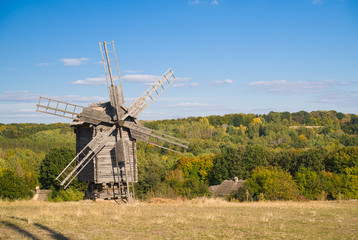 Fototapeta na wymiar Windmill standing in the field against the blue sky