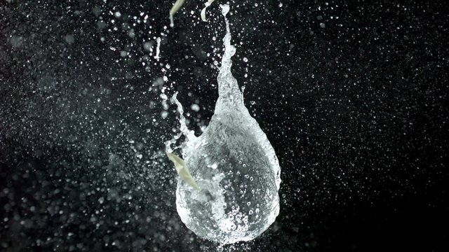 Popping water balloon on black background shooting with high speed camera, phantom flex.