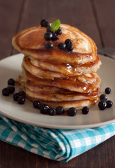 Stack of pancakes with blueberries and maple syrup