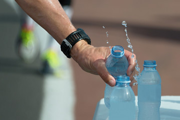 the hand of the runner grabbing the water