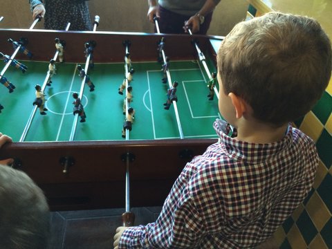 ni&ntilde;os jugando un partido en el futbolin