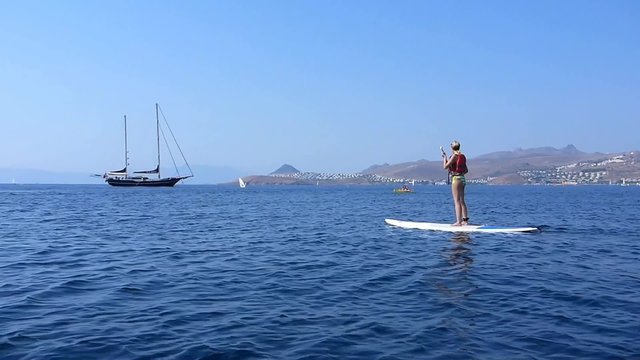 Une femme pratiquant le stand up paddle