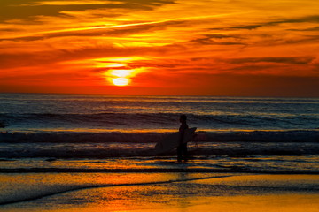 Naklejka premium Silhueta do surfista no por do sol vermelho. Praia de Carcavelos em Cascais Portugal