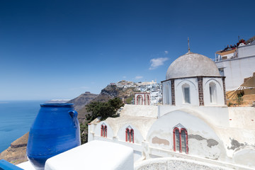 Traditional Greek white church arch with cross and bells in vill