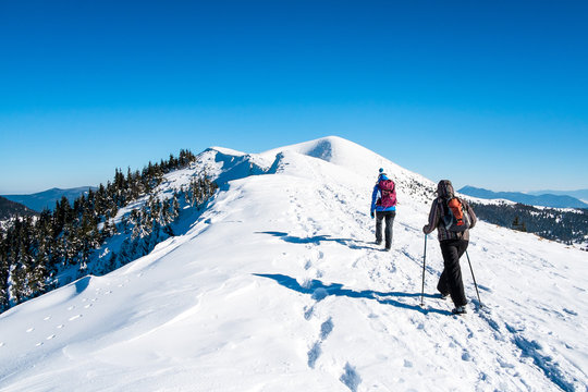 Girls go on snowy mountain peak