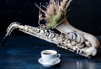 Romantic morning with coffee cup and flowers in saxophone