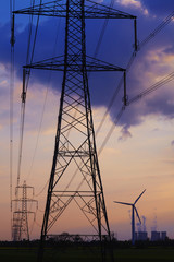 Old coal fired and new wind turbine energy feeding into the national grid via electricity pylons.