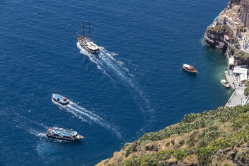 Yacht navigates into beautiful blue water near Santorini island,