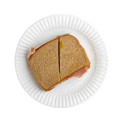Ham and cheese sandwich on a white paper plate