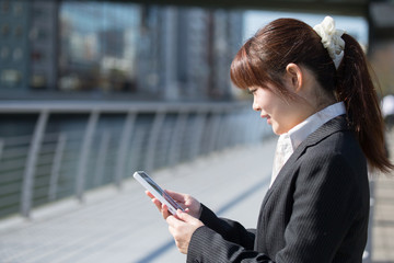 スマホする女性(屋外)