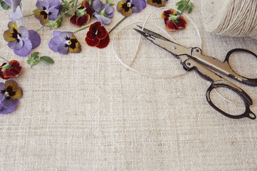 Rustic scissors, twine, pansy flowers  copy space background, vintage tone