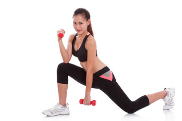 Full length of young woman doing exercise with lifting weights