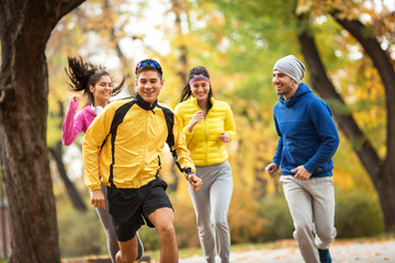 Young friends jogging at the park.Autumn season.