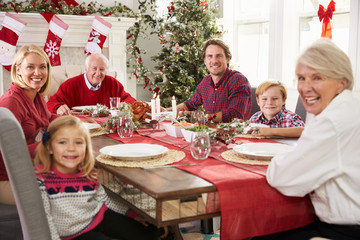 Family With Grandparents Enjoying Christmas Meal At Table