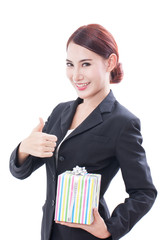 Portrait of beautiful business woman with gift box and showing thumb up.