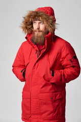 Man wearing red winter Alaska jacket  with fur hood on