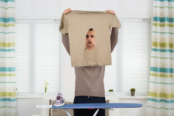 Shocked Man Looking At Iron Burnt Tshirt