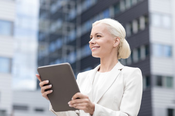 Fototapeta premium smiling businesswoman with tablet pc outdoors
