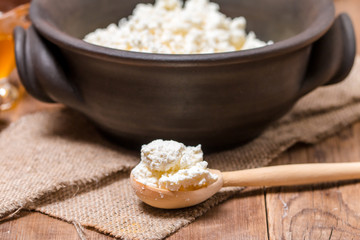 Fresh cottage cheese in a wooden spoon