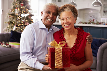 Obraz na płótnie Canvas Senior Couple Exchanging Christmas Gifts At Home