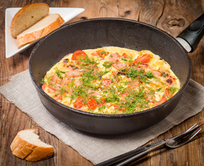 Omelette with sausage, onion, herbs and tomatoes