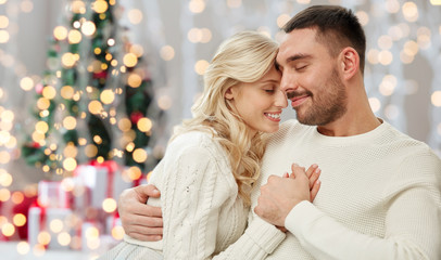 happy couple over christmas tree lights background