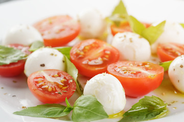 caprese salad with mini mozzarella balls and tomatoes