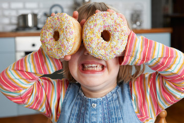Girl Making Glasses Using Sugary Doughnuts