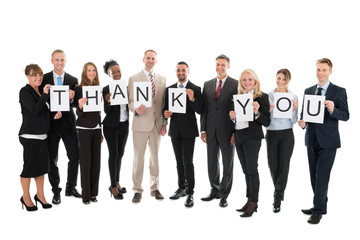 Portrait Of Smiling Business Team Holding Thank You Sign
