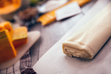 Preparing pie with pumpkins on wooden table, selective focus