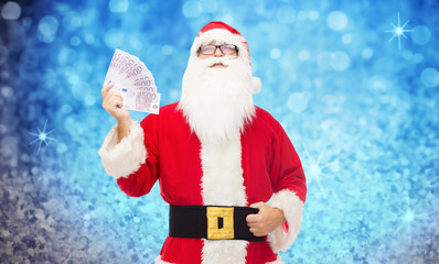 man in costume of santa claus with euro money