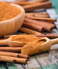 Cinnamon sticks and powder cinnamon in the bowl on table