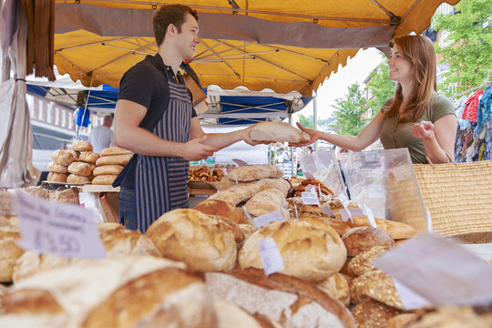 Woman Buying Bread From Market Stall