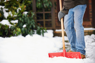 Man Clearing Snow From Path With Shovel - Powered by Adobe