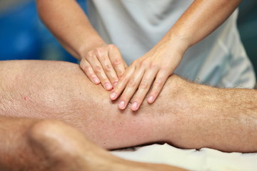 Fototapeta na wymiar hands massaging athlete's thigh after running