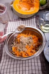 Woman in kitchen making prepares a pie with pumpkin, selective focus